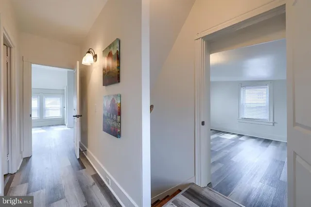a view of a hallway with wooden floor and closet