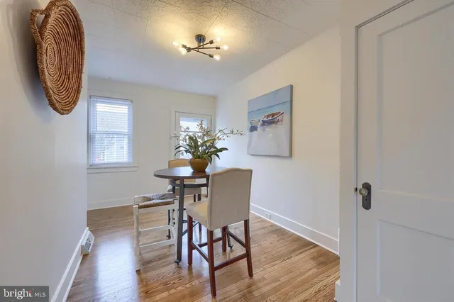 a dining room with chandelier and wooden floor