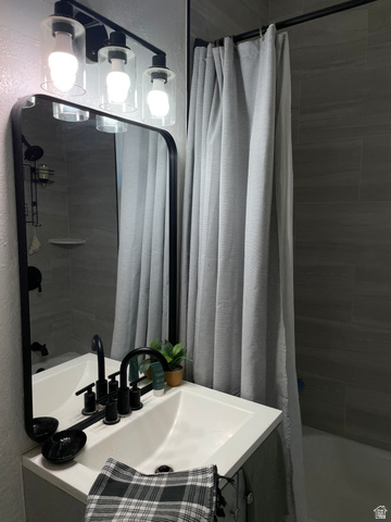 857 27th Street Ogden, UT 84403 - Photo 8 of 20 Bathroom featuring a white vanity with integrated sink, matte black faucet, and rectangular mirror