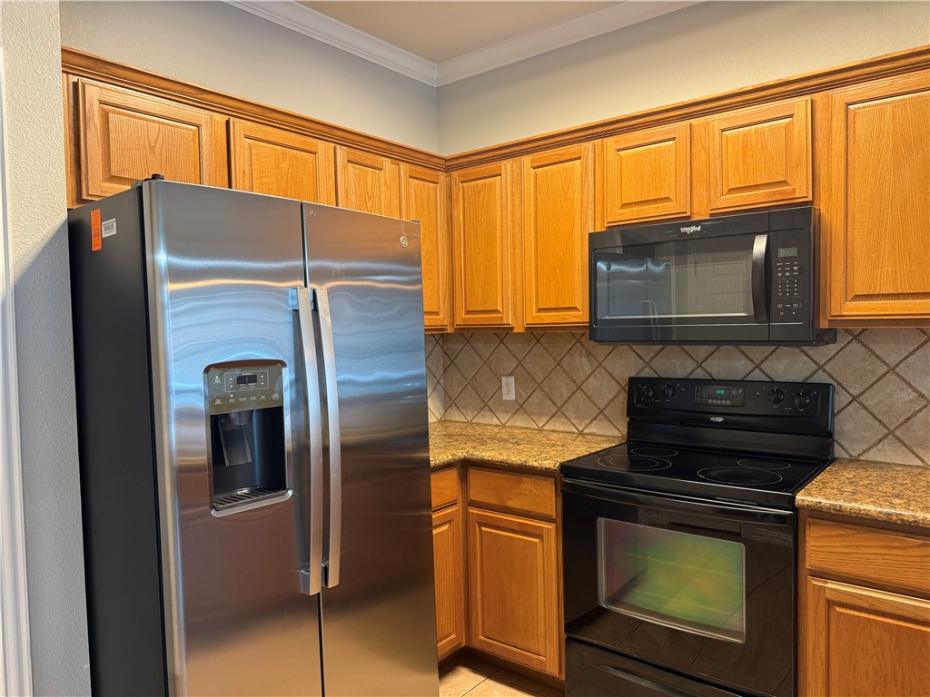 1001 Krenek Tap Road, Unit 2405 College Station, TX 77840 - Photo 9 of 24 a kitchen with stainless steel appliances granite countertop a refrigerator and a stove top oven