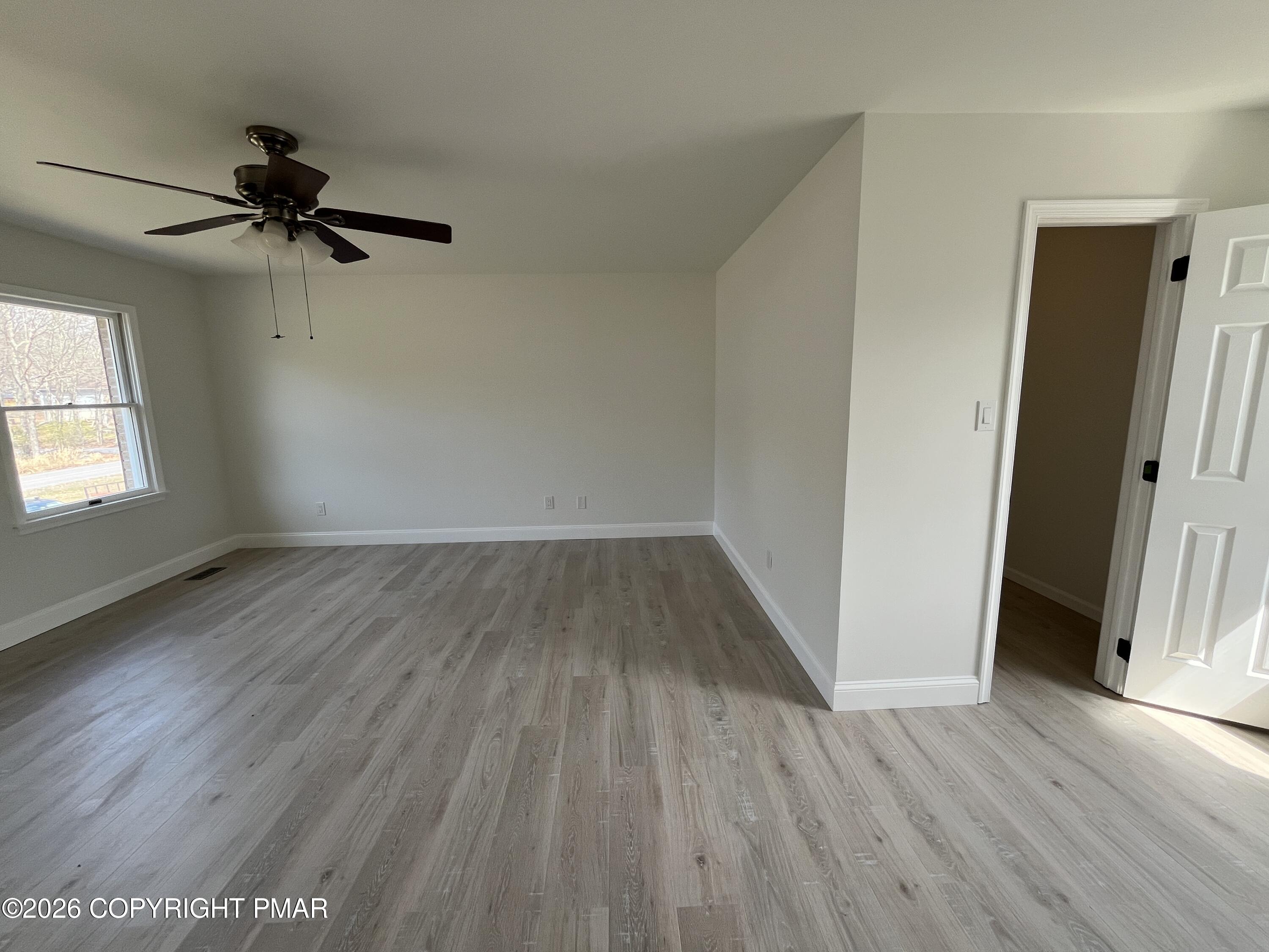 1281 Brian Lane Effort, PA 18330 - Photo 18 of 32 an empty room with wooden floor fan and windows