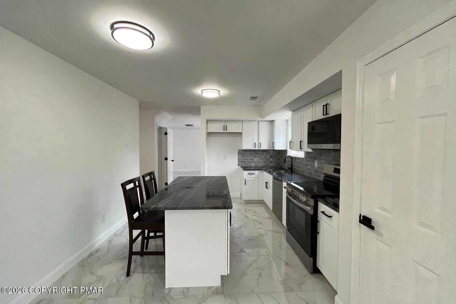 1281 Brian Lane Effort, PA 18330 - Photo 7 of 32 a kitchen with stainless steel appliances kitchen island granite countertop a sink and cabinets