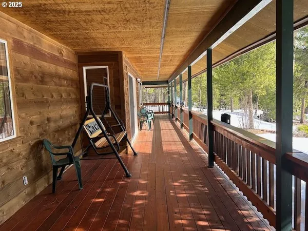 a view of a balcony with chairs and wooden floor