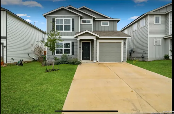 a front view of a house with a yard and trees