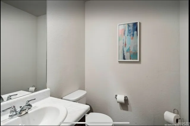 a bathroom with a sink mirror and toilet