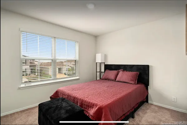 a bedroom with a large bed and a window
