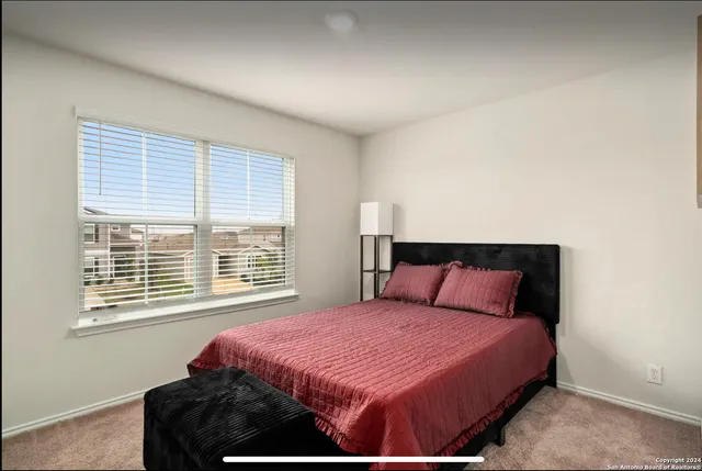 a bedroom with a large bed and a window