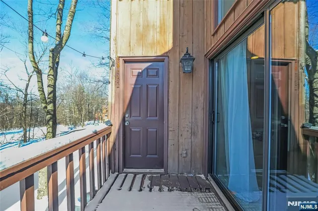 a view of a house with wooden walls and potted plants