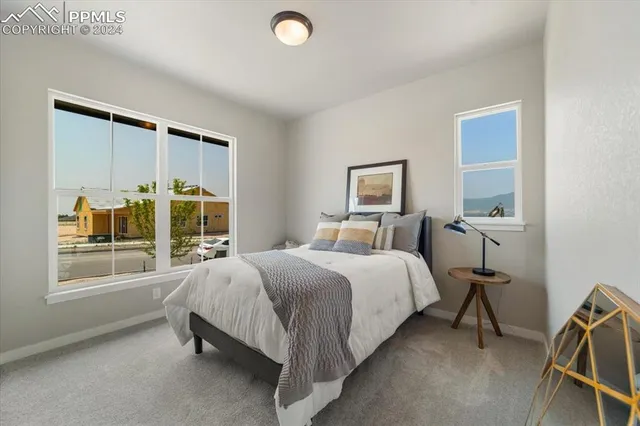 a bedroom with a bed and a large window