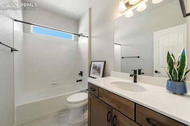 a bathroom with a sink a toilet a mirror and shower