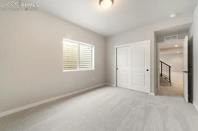 an empty room with windows and closet