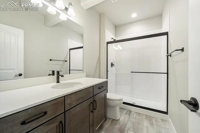 a bathroom with a sink toilet a mirror and shower