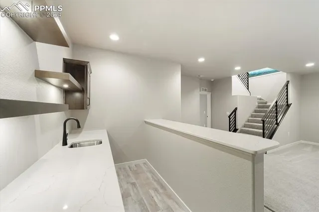 a room with a sink wooden floor and white doors