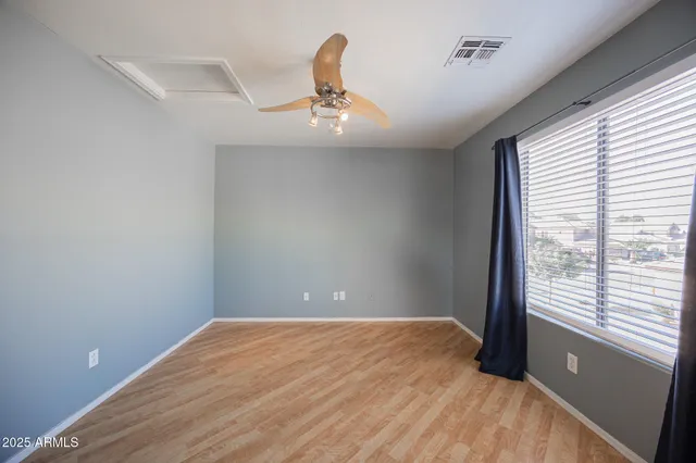 an empty room with ceiling fan and entryway