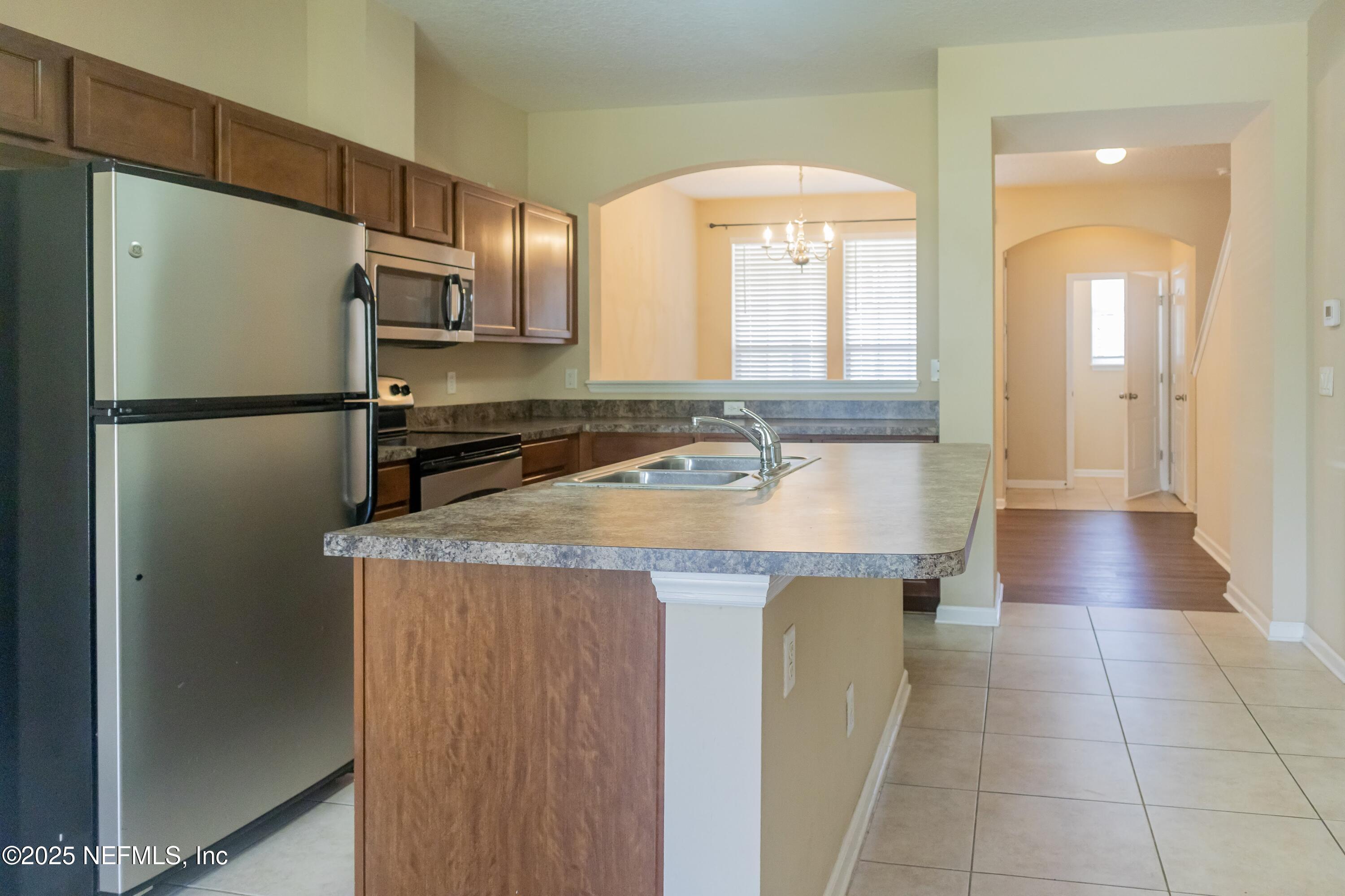 4220 Plantation Oaks Boulevard, Unit 1714 Orange Park, FL 32065 - Photo 3 of 11 a kitchen with a refrigerator a sink and cabinets