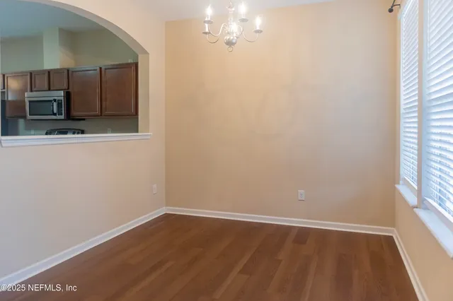 a view of a kitchen with wooden floor and a window