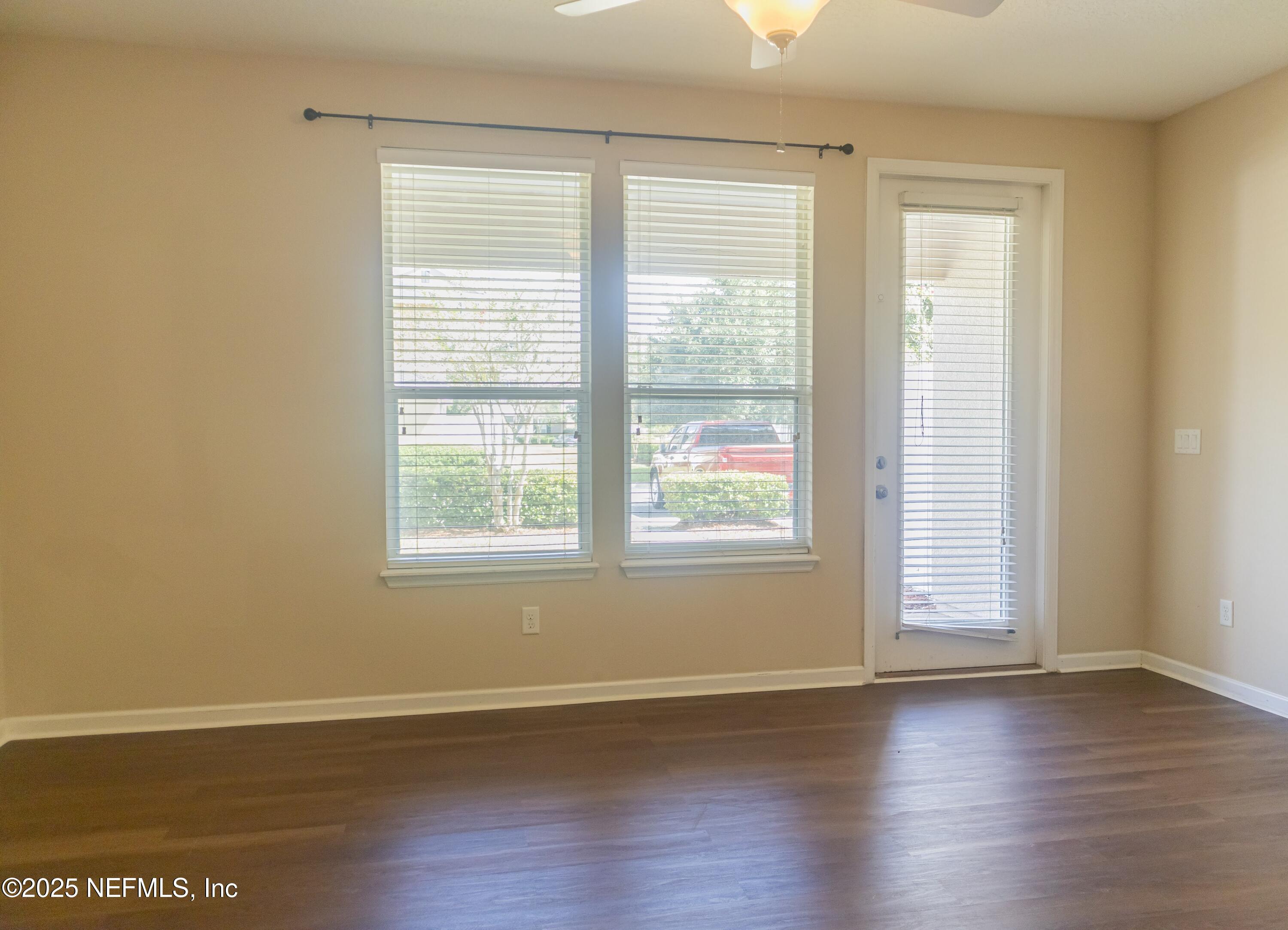 4220 Plantation Oaks Boulevard, Unit 1714 Orange Park, FL 32065 - Photo 5 of 11 a view of an empty room with wooden floor and a window