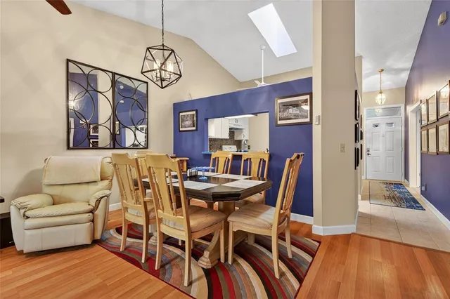 a view of a dining room with furniture a chandelier and wooden floor