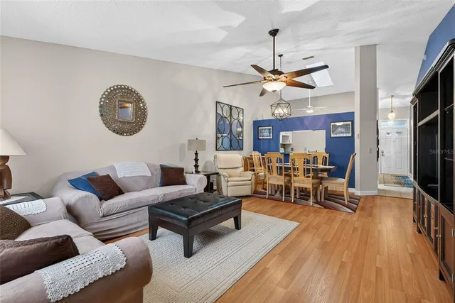 a living room with furniture a wooden floor and a chandelier
