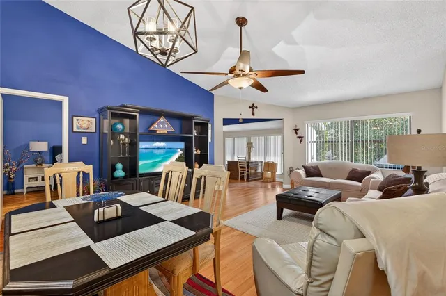a living room with furniture a chandelier and a large window