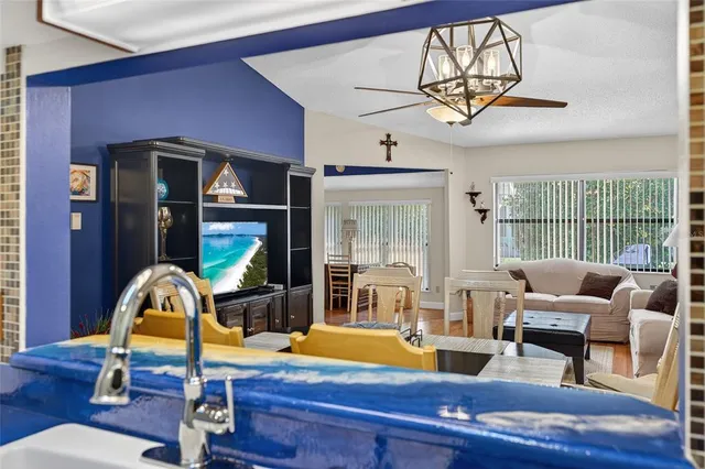 a living room with furniture a chandelier and a large window