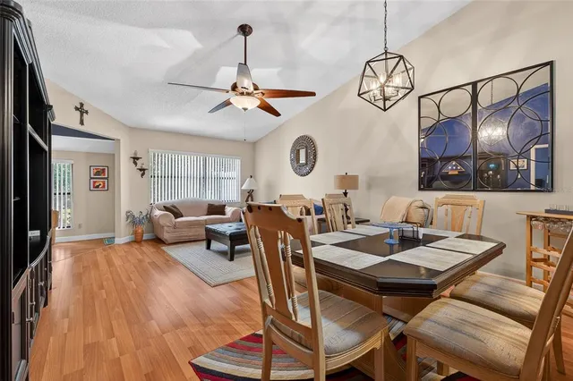 a view of a dining room and livingroom with furniture wooden floor a chandelier