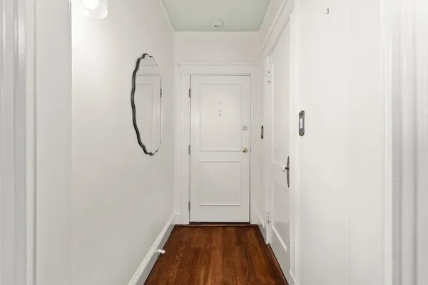 a view of a room with wooden floor and white walls