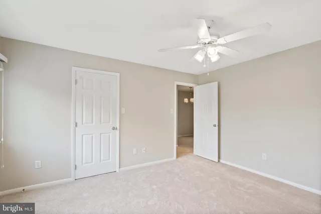 a view of an empty room and chandelier fan