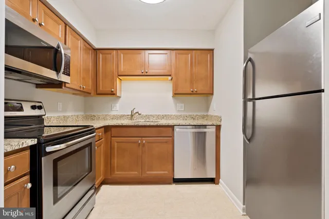 a kitchen with stainless steel appliances granite countertop a refrigerator stove and microwave