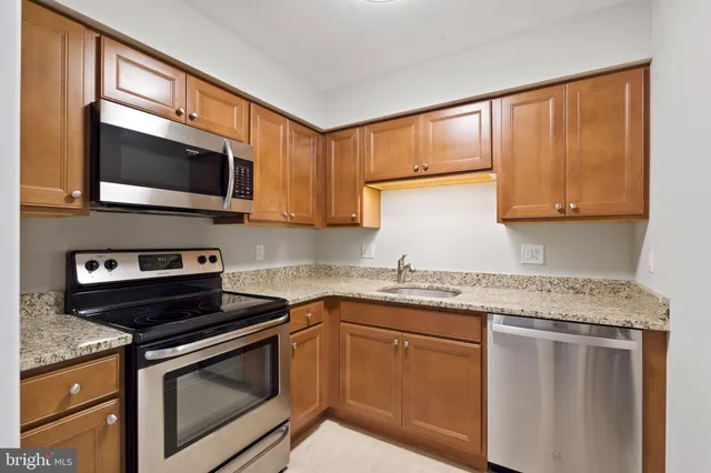 a kitchen with stainless steel appliances granite countertop a stove microwave and sink