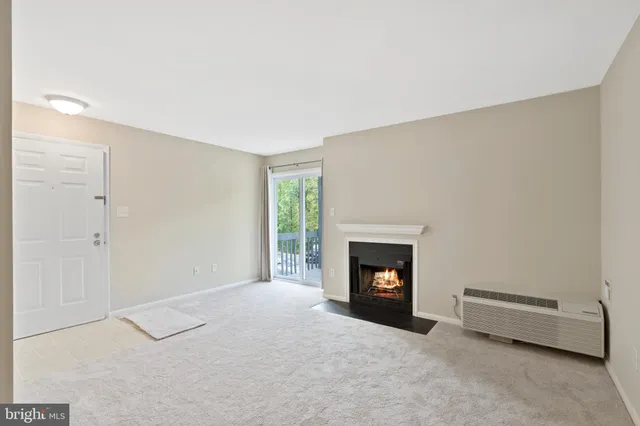 a view of an empty room with a fireplace and a window
