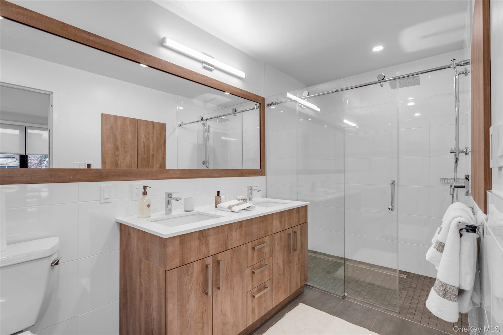 108 Middle Neck Road, Unit 4G Great Neck, NY 11021 - Photo 5 of 9 a bathroom with a double vanity sink and mirror