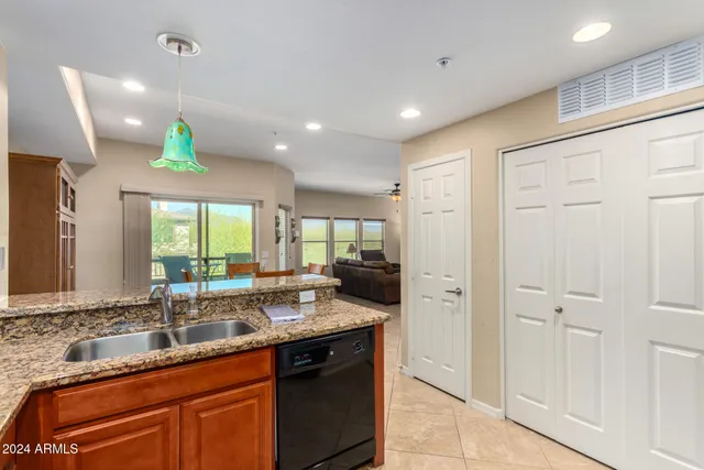 a kitchen with granite countertop a sink stainless steel appliances and cabinets