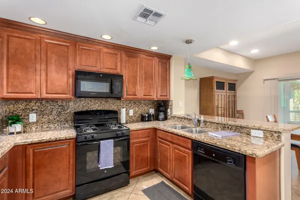 a kitchen with granite countertop wooden cabinets and a stove top oven