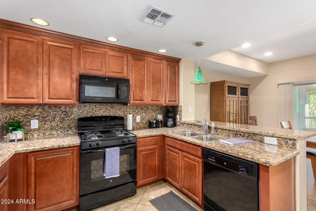 a kitchen with granite countertop wooden cabinets and a stove top oven
