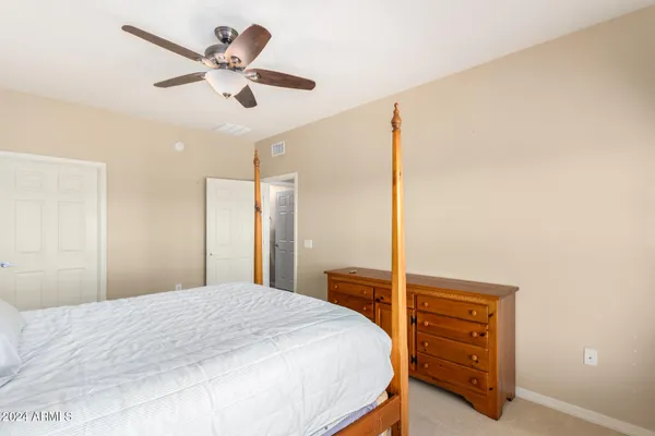 a bedroom with a bed and a ceiling fan
