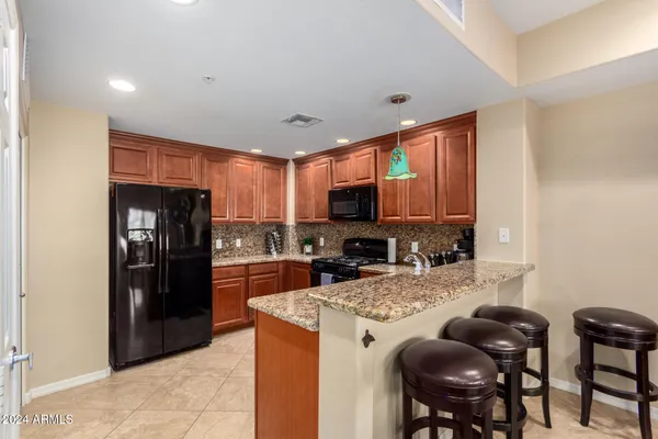a kitchen with stainless steel appliances granite countertop a refrigerator stove top oven a sink and dishwasher