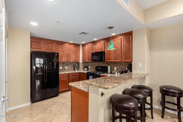 a kitchen with stainless steel appliances granite countertop a refrigerator stove top oven a sink and dishwasher