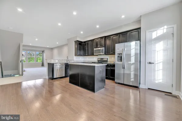 a kitchen with stainless steel appliances a refrigerator and a stove top oven