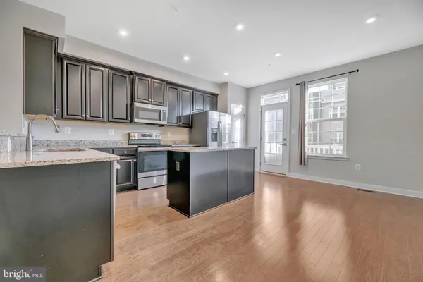 a kitchen with stainless steel appliances granite countertop a stove a sink a refrigerator and a oven