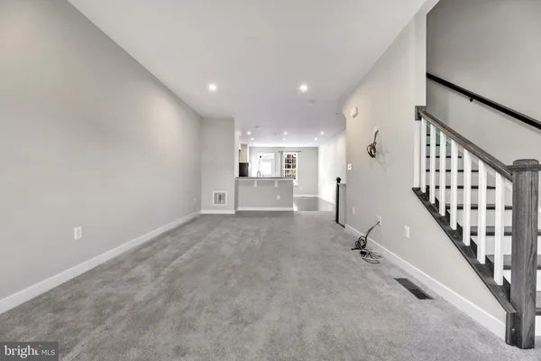 a view of empty room with stairs and mirrors