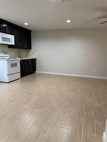 a large kitchen with stainless steel appliances a large counter top a stove a microwave and cabinets