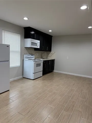 a view of kitchen with stainless steel appliances granite countertop a sink and a stove top oven