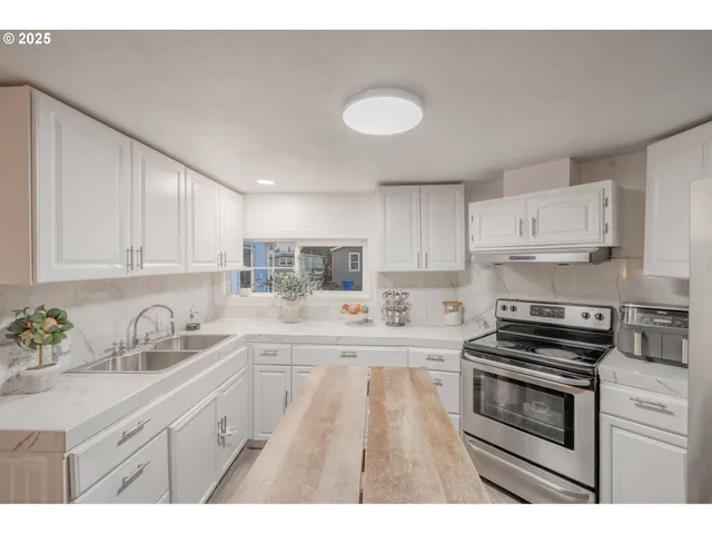 a kitchen with kitchen island a sink stainless steel appliances and cabinets