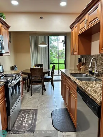 a kitchen with stainless steel appliances granite countertop a stove a sink and a microwave