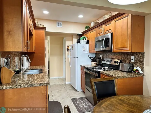 a kitchen with stainless steel appliances granite countertop a sink stove and refrigerator