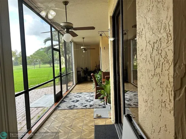 a view of a hallway with the couches and wooden floor