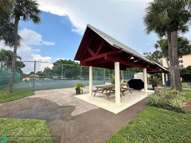 a view of swimming pool with a table and chairs under an umbrella