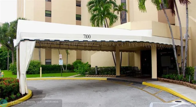 a view of swimming pool with lawn chairs and plants