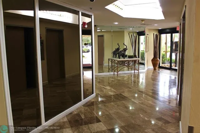 a view of a lobby with furniture and a glass door shower
